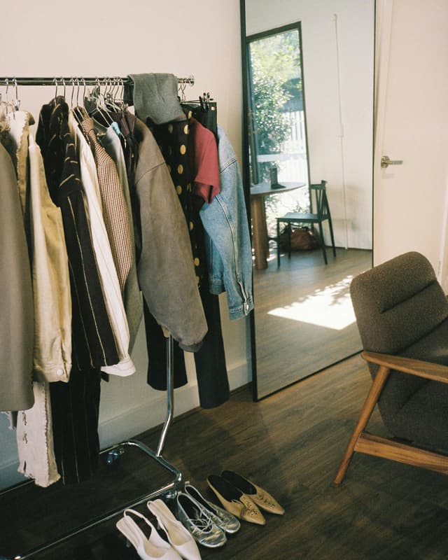 A clothing rack in a modern room displaying various garments