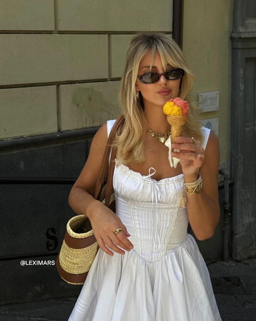 Woman in a white dress wearing oval sunglassses